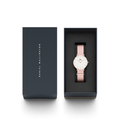 ネイビーのブランドギフトボックスに収められたPetite Rosewater。ライトピンクのNATOストラップとローズゴールドのケースが黒いクッションカバーの上で美しく映え、贈り物にぴったりの上品な仕上がりです。