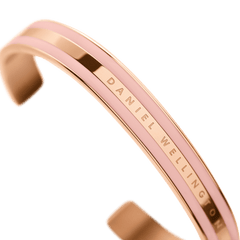 Emalie Bracelet Dusty Rose Rose Goldの細部を捉えたクローズアップ画像です。ポリッシュ仕上げのローズゴールドとダスティローズのエナメルが交互に配された3本ラインの質感や、中央のバンドに刻印されたDaniel Wellingtonのロゴがご覧いただけます。