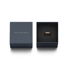 Daniel Wellington Classic Ring ローズゴールドのギフトボックス入りパッケージの写真です。ネイビーのブランドロゴがあしらわれたボックスの蓋と、黒いクッショントレーに収められたリングが並んでいます。