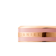 Emalie Ring Dusty Rose Rose Goldのクローズアップ画像です。ダスティローズのエナメル部分に挟まれたローズゴールドのセンターバンドにはDaniel Wellingtonのロゴが刻印され、二重構造の細部までご確認いただけます。