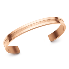 ダニエルウェリントン Elan Bracelet ローズゴールドを斜めから撮影した商品画像。ポリッシュ仕上げのボディにブランドロゴが刻まれ、中央の溝が光を反射して立体感を演出するオープンカフタイプのステンレススチール製ブレスレットです。