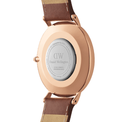 Classic St Mawes Amber Rose Goldのケースバックを撮影した画像です。ローズゴールドのPVDメッキ加工を施したケースには、Daniel Wellingtonのロゴとシリアルナンバーが刻印されており、ブラウンレザーストラップのラグ接続部分も確認できます。
