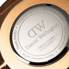 Classic Glasgow Rose Goldの裏蓋をクローズアップした画像です。ステンレススチール製の裏蓋にはDaniel Wellingtonのロゴ、シリアルナンバー、3ATM防水の表記が刻印されており、ローズゴールドのケースの縁が周囲に見えています。