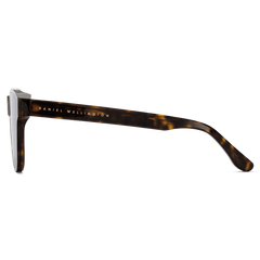 アンブラー Bio-Acetate Dark Havanaを真横から撮影した画像です。ダークハバナのべっ甲柄フレームが持つ奥行きのあるカラーパターンと、テンプル外側に配されたゴールドのDaniel Wellingtonロゴが際立っています。