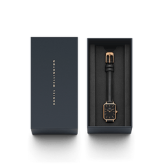 Quadro Pressed Sheffield Black Rose Goldが、ダークネイビーのDaniel Wellington専用ギフトボックスに収められています。ブラックレザーストラップとローズゴールドケースの腕時計は、ブランドロゴ入りの蓋とともに、贈り物にふさわしい上品なパッケージでお届けします。