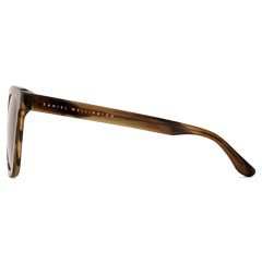 Grande Bio-Acetate Brown Demiのサングラスをサイドから見た様子です。テンプルの外側にはゴールドで刻印されたDaniel Wellingtonのブランドロゴが、また琥珀色の濃淡が美しいべっ甲柄のバイオアセテート素材のディテールが確認できます。