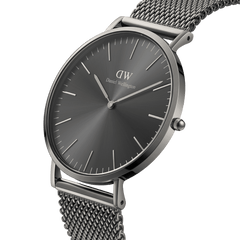 Daniel Wellington Classic Mesh Graphiteを斜めから捉えたクローズアップ画像です。薄型ケースの立体的なラグの造形や、光を受けて放射状に陰影が広がるサンレイダイヤルの細部までご確認いただけます。
