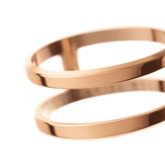 Daniel WellingtonのElan Dual Ring ローズゴールドをクローズアップ。2本のリングの間に設けられた空間と、ポリッシュ仕上げのローズゴールドケースが柔らかな光を受けて滑らかに輝く質感がお分かりいただけます。