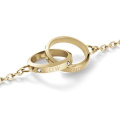 Classic Lumine Unity Goldのペンダント部分をクローズアップした画像です。大小ふたつのゴールドリングが交差し、リング表面に刻まれたロゴとプレシオサ製クリスタルの繊細な輝きが際立ちます。