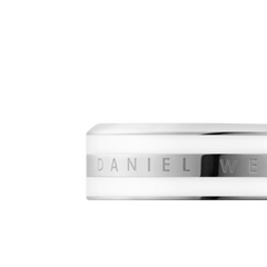 Daniel Wellington Emalie Ring Silverのクローズアップ画像です。シルバースチール中央に施されたブランドロゴの刻印と、その上下にあしらわれたサテンホワイトエナメルの質感やポリッシュ加工の輝きが、細部までご確認いただけます。