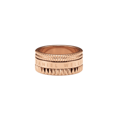 ローズゴールド仕上げのElevation Ring Rose Goldを斜め上から撮影した画像です。上下のスタッズが光を受けて美しい陰影を描き、中央のバンド部分にはDaniel Wellingtonのロゴが刻印されています。