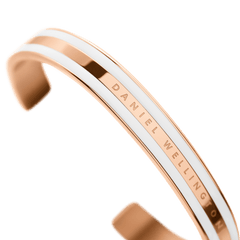 Emalie Bracelet Satin White Rose Goldを斜めからとらえたクローズアップ画像です。カフの開口部からなめらかなカーブにかけてのフォルムが確認でき、ポリッシュ加工のローズゴールドとサテンホワイトエナメルのコントラストが光を受けて美しく輝きます。