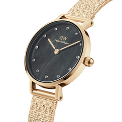 Petite Lumine Pressed Piano Black MoP Goldを斜めからとらえたクローズアップ画像です。ブラックマザーオブパールの文字盤に浮かぶ繊細な虹彩効果と、ゴールドケースの上品な輝き、Pianoメッシュストラップの立体感ある質感が際立ちます。