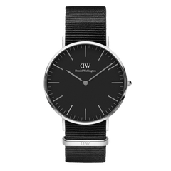 Classic Cornwall Black Silverの真正面から撮影した商品画像です。ブラックの文字盤にはシルバーの時分針が静かに時を刻み、等間隔に配置されたバーインデックスがミニマルな美しさを引き立てています。ブラックのNATOストラップはシルバーケースと一体となり、モノトーンの洗練された佇まいを演出します。