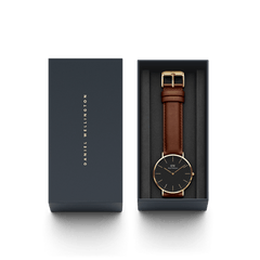 Daniel WellingtonのClassic St Mawesが、ネイビーの専用ギフトボックスに収められています。ブラック文字盤とブラウンレザーストラップの腕時計が丁寧にセットされており、贈り物にも最適なパッケージです。
