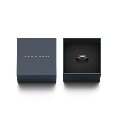 Daniel WellingtonのEmalie Ring Rose Gold Blackが、ネイビーのブランド専用ギフトボックスに収められています。蓋にはゴールドのブランドロゴが刻印されており、ギフトとしても喜ばれる上品なパッケージです。