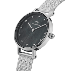 Petite Lumine Pressed Piano Black MoP Silverを斜めから捉えたクローズアップ画像です。黒蝶貝のダイヤルが放つ深みのある色合いと、光の当たり具合で変化する虹色の輝き、クリスタルインデックスの繊細なきらめき、そしてPressed Pianoストラップのプレス加工による立体感のある質感がおわかりいただけます。