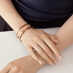 ネイビーのトップスに合わせたDaniel WellingtonのElan Braceletローズゴールドを重ね付けしたスタイリングです。複数のカフブレスレットを重ねることで、手元に洗練された印象を演出します。