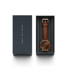 Classic St Mawes Amber Rose Goldをネイビーのギフトボックスに収めたパッケージ画像です。箔押しのブランドロゴが施された蓋と、アンバーの文字盤にブラウンのレザーストラップを合わせた本体が、整然と並んでいます。