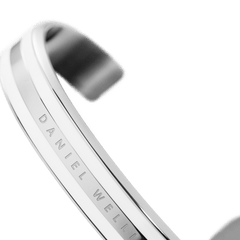 Daniel Wellington Emalie Braceletシルバーの内側をクローズアップした画像です。中央のバンド部分にはDaniel Wellingtonの刻印が施され、ポリッシュ仕上げのステンレススチールの美しい光沢が確認できます。