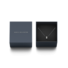 Elan Necklace シルバーが、Daniel Wellingtonのネイビーのギフトボックスに収められています。ブランドロゴ入りの蓋と黒いクッションの上に、リングペンダントネックレスが丁寧にセットされており、贈り物にぴったりのパッケージです。