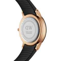 Iconic Motion Rose Goldの裏蓋を写した画像です。ステンレススチール製の裏蓋にはDaniel Wellingtonのロゴやシリアルナンバー、10気圧防水の刻印が放射状に配されており、ローズゴールドケースとブラックラバーストラップの接続部分もご覧いただけます。