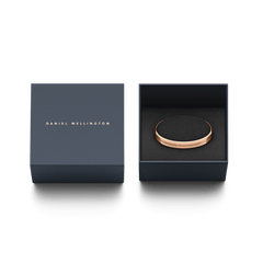 ダニエルウェリントン Elan Bracelet ローズゴールドが、ブランドロゴ入りのネイビーギフトボックスに収められています。ブラックのクッションにセットされたブレスレットは、贈り物に最適なパッケージです。