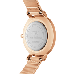 Petite Lumine Pressed Piano White MoP Rose Goldの裏蓋側を撮影した画像です。ローズゴールドのケース裏面にはDaniel Wellingtonのロゴとシリアルナンバーが刻印されており、Pianoストラップとケースを繋ぐクイックリリース機構もご確認いただけます。