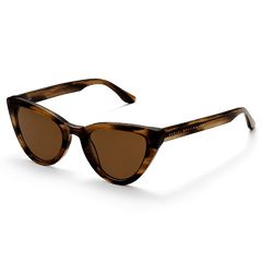 Lynx Bio-Acetate Brown Demiのサングラスを斜め前方から撮影した商品画像です。琥珀色とダークブラウンが混ざり合ったべっ甲柄のキャットアイフレームで、テンプル部分にはゴールドのDaniel Wellingtonロゴが刻印されています。