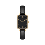 Daniel Wellington Quadro Pressed Sheffieldの正面画像。ゴールドのレクタンギュラーケースにブラックダイヤルとゴールドのバーインデックスを配し、ブラックレザーストラップを合わせたスクエアフェイスの腕時計です。