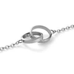 Elan Unity Necklaceのインターロッキングリング部分をクローズアップした画像です。ポリッシュ仕上げのシルバーカラーが光を反射して輝き、リングの側面にはDaniel Wellingtonのロゴがさりげなく刻印されています。