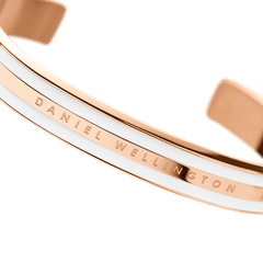 Emalie Bracelet Satin White Rose Goldの細部をご紹介します。ポリッシュ仕上げのローズゴールド中央バンドにはDaniel Wellingtonのロゴが刻印され、両側のサテンホワイトエナメルのなめらかな質感が際立ちます。