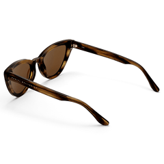 Lynx Bio-Acetate Brown Demiのサングラスを背面斜めから撮影した画像です。レンズ左側にはゴールドのDaniel Wellingtonロゴが入り、べっ甲柄のバイオアセテートフレームが持つ奥行きのある色合いと、キャットアイの立体的なフォルムが際立っています。