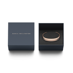 ダニエルウェリントンのネイビーギフトボックスに収められたEmalie Bracelet Satin White Rose Gold。ブランドロゴがあしらわれた蓋と、黒いクッションケースに丁寧にセットされたブレスレットが、贈り物にぴったりの上品なパッケージを演出します。
