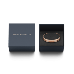 Emalie BraceletのDesert Sand Rose Goldとダークネイビーのギフトボックスを並べた画像です。箔押しされたブランドロゴがあしらわれた蓋の横には、黒いクッションケースにブレスレットが収められており、贈り物にぴったりの上品なパッケージです。