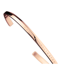 Classic Bracelet Rose Goldを斜めから捉えた画像です。ブランドロゴの刻印とオープンカフの開口部が確認でき、ローズゴールドのPVDメッキによる鏡面仕上げが白い背景に映えています。