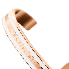 Emalie Bracelet Satin White Rose Goldを内側から見たアングルです。中央のバンド部分にはDaniel Wellingtonのブランドネームが刻印され、その両側にはサテンホワイトエナメルの均整のとれた3本ラインが施されています。
