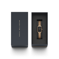 Quadro Pressed Melrose Black Rose Goldが、ダークネイビーのDaniel Wellington専用ギフトボックスに収められています。ブラックの文字盤を持つスクエア型の腕時計がクッション素材に丁寧にセットされ、贈り物にぴったりの上品なパッケージングです。