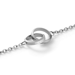 Elan Unity Braceletのインターロッキングリング部分をクローズアップした画像です。2つのシルバーリングが交差し、片方のリング側面にはDaniel Wellingtonのロゴ刻印が施されています。ポリッシュ仕上げのステンレススチールが光を反射し、美しい輝きを放っています。
