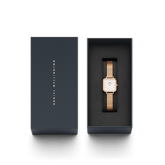 Quadro Studio Rose Goldがネイビーのギフトボックスに収められた状態です。蓋にはDaniel Wellingtonのロゴがゴールドで刻印され、ボックス内のクッションにはローズゴールドのスクエアウォッチが丁寧にセットされています。贈り物にぴったりの上品なパッケージです。