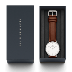 Classic St Mawesのシルバーモデルをネイビーの専用ギフトボックスに収めた画像です。ブラウンのレザーストラップとオフホワイトの文字盤が、ダークグレーのクッション素材に映え、贈り物にぴったりの上品なパッケージングがご覧いただけます。