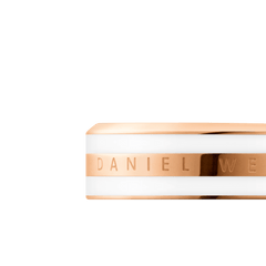 Emalie Ring Satin White Rose Goldのクローズアップ画像です。ポリッシュ仕上げのローズゴールドバンドにはDaniel Wellingtonの刻印が施され、上下を挟むサテンホワイトエナメルのなめらかな質感が際立ちます。