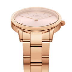 Iconic Link Pink Rose Goldのケースからブレスレットへの流れるようなつながりを際立たせたアングルの画像です。テーパー形状の3ピースリンクがケースとシームレスに連なり、サテン仕上げとポリッシュ仕上げのコントラストが光を受けて美しく輝いています。