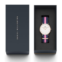 クラシックなデザインのWinchester Rose Goldが、ネイビーのブランドギフトボックスに収められた画像です。ネイビーとピンクのNATOストラップを装着したローズゴールドケースの腕時計が、黒いクッションの上に丁寧にセットされており、贈り物にぴったりの上品なパッケージングとなっています。