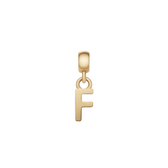 Daniel WellingtonのLetter Charm Gold「F」です。磨き上げられたゴールドの表面が上品な光沢を放ち、上部のベイルを通してチェーンやブレスレットに取り付けられます。