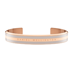 Emalie Bracelet Desert Sand Rose Goldをやや上方から撮影した画像です。開口部が見えるカフタイプのフォルムと、デザートサンドカラーのエナメルを挟んだローズゴールドのフレームが持つ温かみのある色合いがおわかりいただけます。