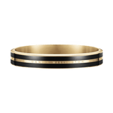 Emalie Infinite Gold Blackブレスレットを正面から捉えた画像です。ブラックエナメルの二本のラインと、ゴールドの中央バンドに刻まれたDaniel Wellingtonのロゴが際立つ、閉じた状態のバングルです。